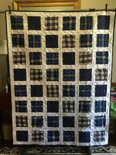 a large blue and white quilt hanging on a wall