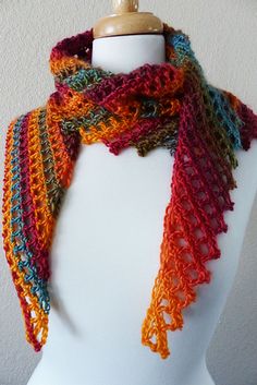 a white mannequin wearing a multicolored scarf