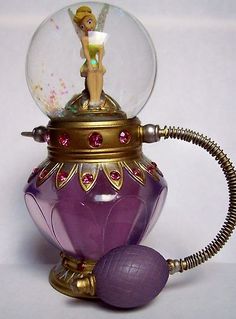 a purple glass figurine with a fairy on top and a ball attached to it