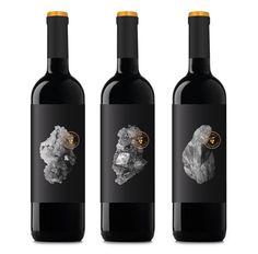 three bottles of wine with rocks on them