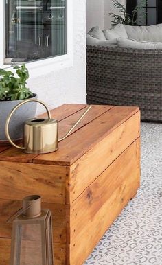 a wooden box sitting on top of a floor next to a planter filled with flowers