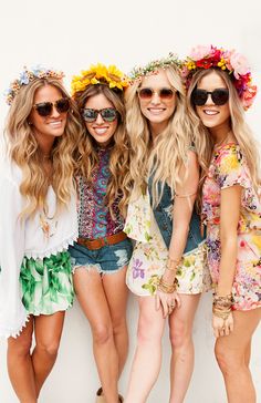 three beautiful young women standing next to each other wearing sun glasses and flower headbands