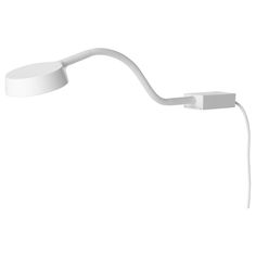 a white light that is on the side of a wall mounted lamp with a cord attached to it