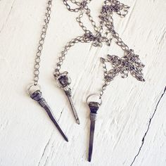 Unconventional yet striking, this relic antique coffin nail necklace exudes a mystical aura and playful witchy charm! The vintage coffin nail, salvaged from old wooden boards and/or rescued horse shoes (not real coffins!), is believed to ward off negativity, ill will, and malicious intentions. Hand-forged by skilled Blacksmiths, these nails are fittingly called coffin nails due to their square iron shape. Choose your style wisely! The nail can be adorned with copper, natural brass, pewter or sil Nail Necklace, Nails Necklace, Vintage Nails, Horse Shoes, Wooden Boards, Copper Chain, Jewelry Cleaner, Blacksmithing, Hand Forged