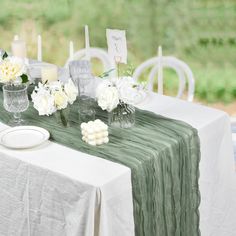 the table is set with white flowers and candles