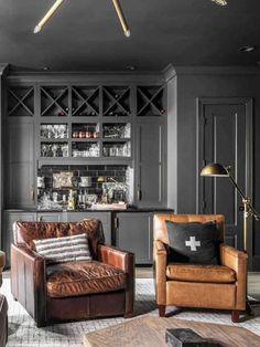 a living room filled with furniture and a bar in the backround, surrounded by black walls