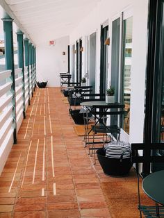 an empty restaurant with tables and chairs lined up on the outside wall, facing the street