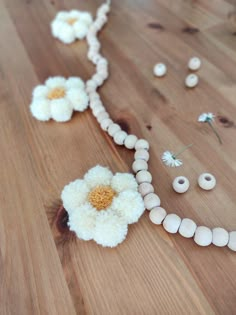 white beads and flowers on a wooden table