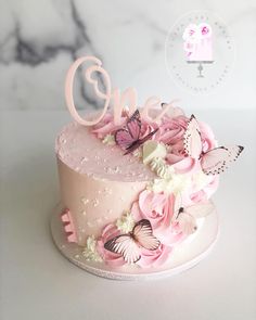 a pink cake with flowers and butterflies on it's top is the number one