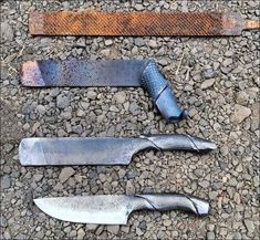 three knives are laying on the ground next to some rusted metal bars and grates