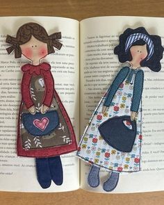 an open book with two paper dolls on it