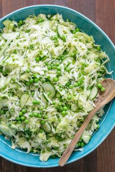 a blue bowl filled with shredded cucumbers and peas