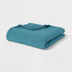 a blue blanket folded on top of a white surface