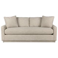 a beige couch with three pillows on it's back and one arm facing the camera