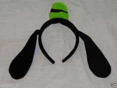 a black and green headband with two ears on top of a white bed sheet