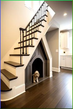 a dog is sitting in his house under the stairs