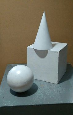 a white object sitting on top of a table next to a ball and cement block