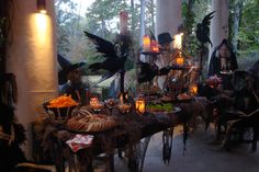 a table with halloween decorations on it in the middle of a room filled with candles