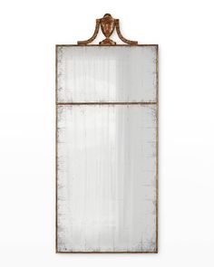 an old mirror hanging on the wall with a coat rack attached to it's side