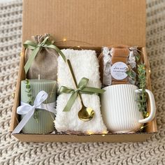 an open box with tea, coffee mug and other items in it on a carpeted surface