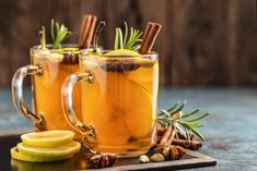 two mugs filled with cinnamon and apple cider