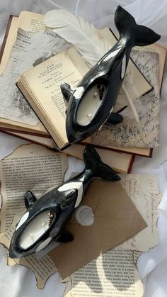 an orca whale sculpture sitting on top of two open books