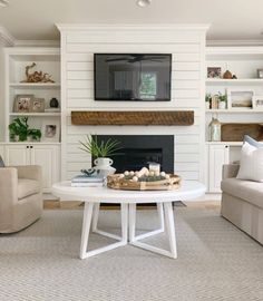 a living room filled with furniture and a flat screen tv mounted on the wall above a fireplace