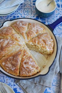 a cake in a pan on top of a blue and white tablecloth with silverware