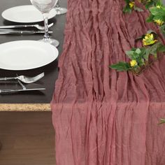 the table is set with white plates and silverware, along with red linen draped over it