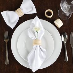 a place setting with napkins, silverware and flowers