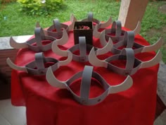 a table topped with red cloth covered in paper cut out of metal strips and scissors