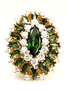 A real statement! This Solid Retro18K Yellow Gold 9.73ctw Diamonds and Gorgeous World Gem Quality Dark Green Tourmaline Cocktail Ring will take your breath away!The masterful design of this ballerina ring CIRCA 1960s features 17 marquise-cut green tourmaline, approx. 7.70 carat total, accented by 28 round-cut diamonds, brilliant and very shiny, approx. 1.73 carat total, G - H - I color, SI clarity, in a marquise-shaped cluster ring from our Estate collection propels it into the arena of glamorou Ballerina Ring, Retro Jewelry, Green Tourmaline, Marquise Cut, Diamond Cluster, Cluster Ring, Cocktail Ring, Round Cut Diamond, Cocktail Rings