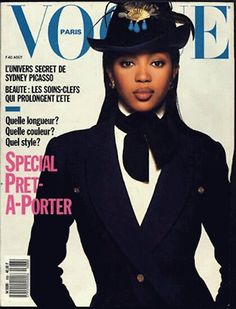 a woman in a black suit and hat on the cover of a magazine