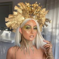 a woman with white hair and gold makeup