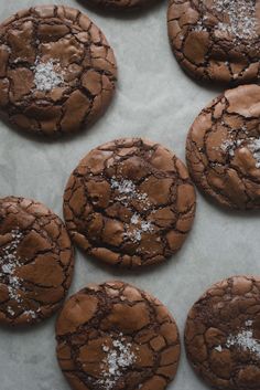 chocolate cookies with powdered sugar on top are lined up in a baking sheet, ready to be eaten