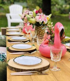 a table set with plates and flamingo decorations