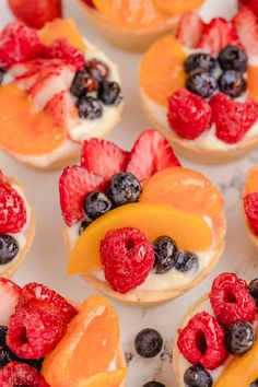 small pastries with fruit on them sitting on a table