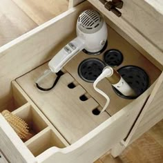 an electric hair dryer is sitting in a drawer with other items on the drawers