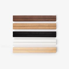 four different colors of wood on a white background, one is black, the other is brown