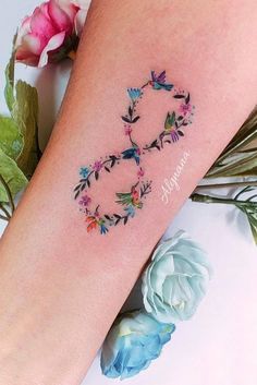 a woman's arm with flowers and the word love tattooed on her left leg