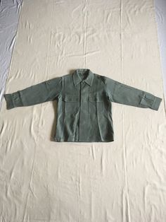 "vintage military man's field shirt cotton sateen, sage green specification MIL-S-4336-B SIZE 15 x 33 (refer to actual measurements for true fit) Marine Corps Clothing Depot adjustable 2 button sleeve cuffs 2 breast pockets w/button flaps straight hem side slits back vertical shoulder darts good vintage condition, removed patches marks right pocket has mismatched button starched w/creases measures, lying flat, shoulder-17\" chest-21\" sleeve-23\" length (from back neck at bottom of collar)-27 3/4\" classic staple to any vintage wardrobe     We do not offer returns or refunds unless something is grossly misrepresented. Please contact us within 2 business days of receiving to discuss any possible returns for this reason. We do not offer refunds for your shipping fees. Please feel free to con Khaki Military Collared Shirt, Khaki Collared Military Shirt, Olive Military Style Button-up Top, Olive Military Style Collared Top, Military Green Shirt For Fall, Vintage Playsuit, Cocktail Dress Vintage, Vintage Suits, Vintage Wardrobe