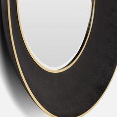 a black and gold mirror on a white wall