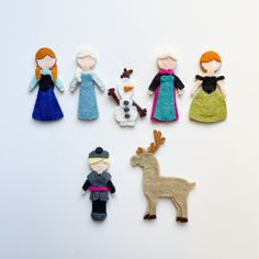 several felt dolls are arranged in the shape of snowmen, princesses and reindeers