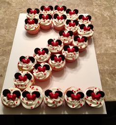 cupcakes are arranged in the shape of a heart and mickey mouse head on a white tray