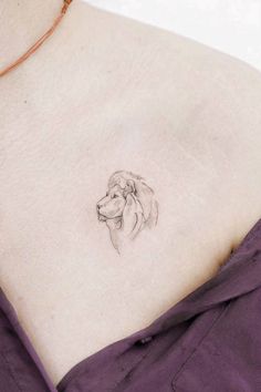 a woman's chest with a small tattoo of a dog on it, and the back of her neck