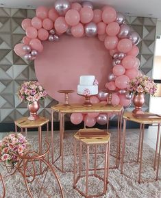 a table and chairs with balloons on the wall in front of it, along with other decorations