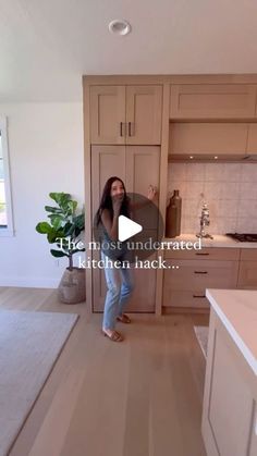 a woman is standing in the middle of a kitchen