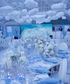 the tables are set with white flowers and blue napkins for an elegant wedding reception