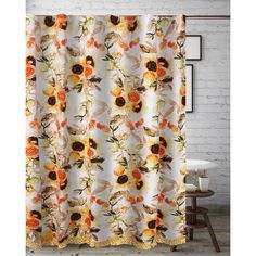 a shower curtain with sunflowers and other flowers on it in front of a brick wall