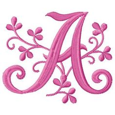 an embroidered monogrammed letter with pink flowers and leaves in the center on a white background